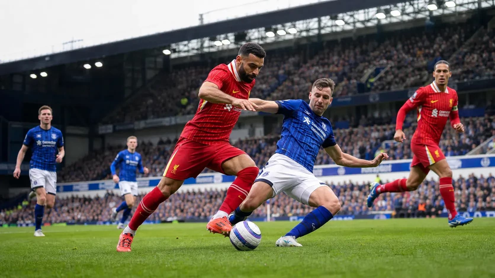 Jugador de Liverpool y Everton luchando por el balón