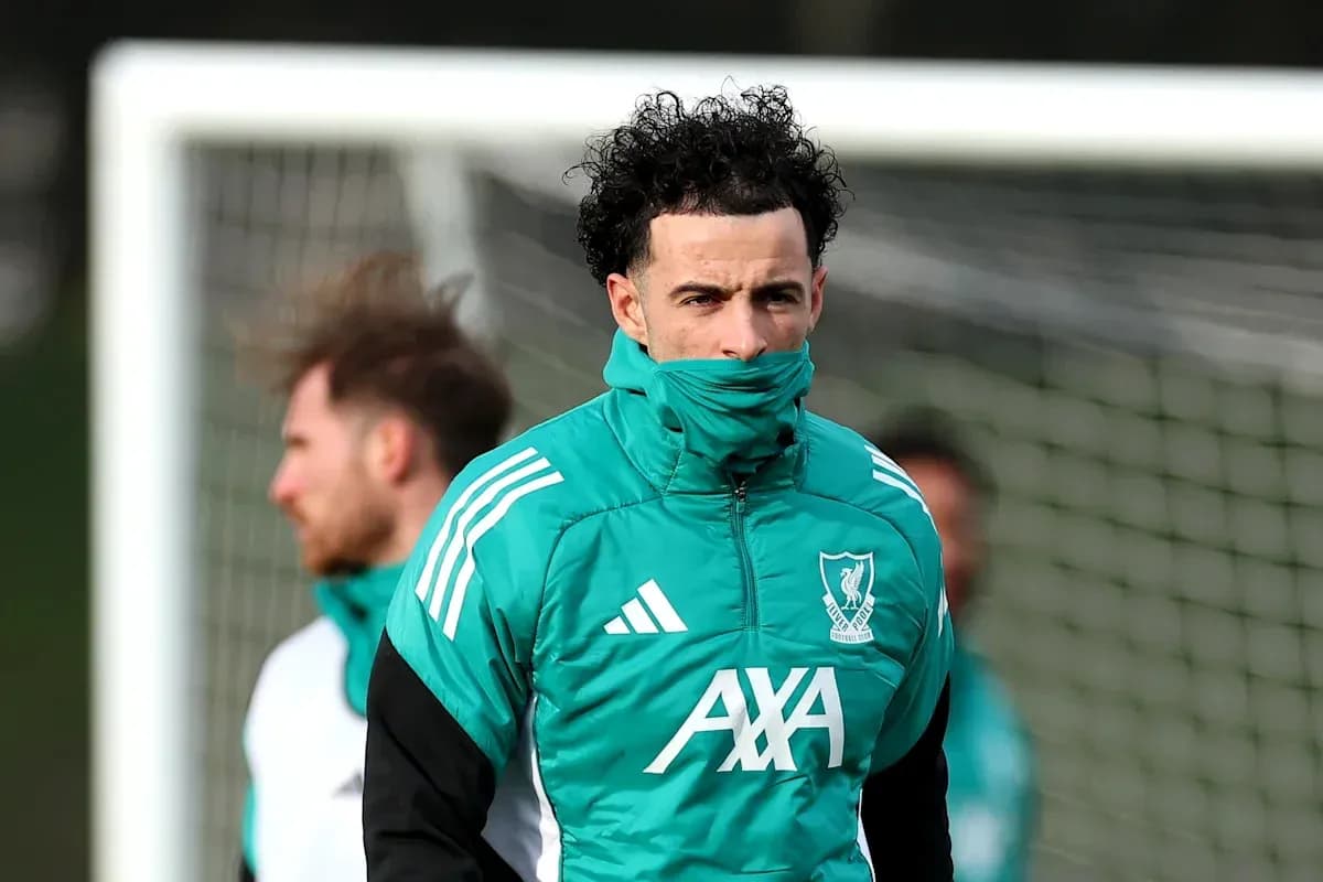 Jugador de Liverpool entrenando con abrigo en el campo Jugador de Liverpool entrenando con abrigo en el campo