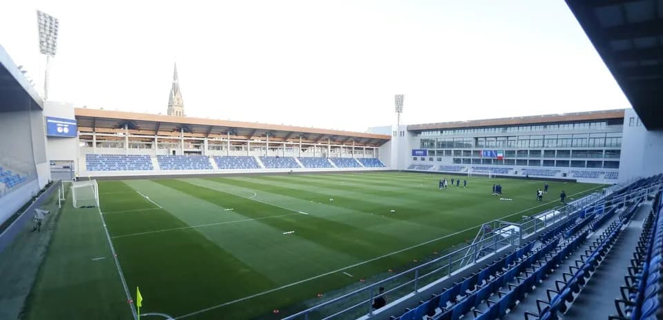 Vista del estadio con jugadores en el campo de entrenamiento