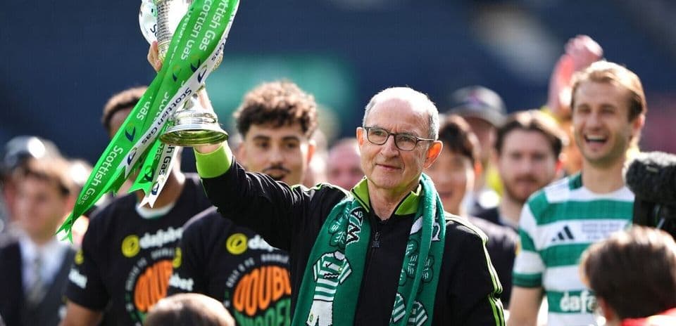 Entrenador sosteniendo el trofeo en celebración