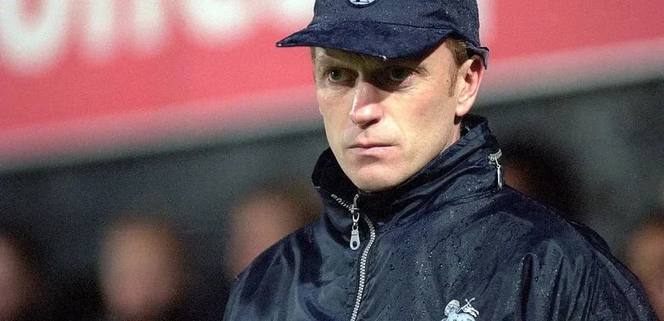 Entrenador observando el partido bajo la lluvia