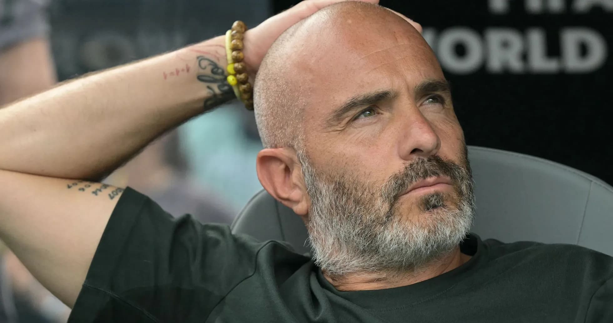 Entrenador sentado con la mano en la cabeza