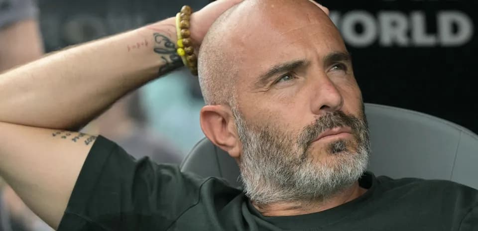 Entrenador sentado con la mano en la cabeza