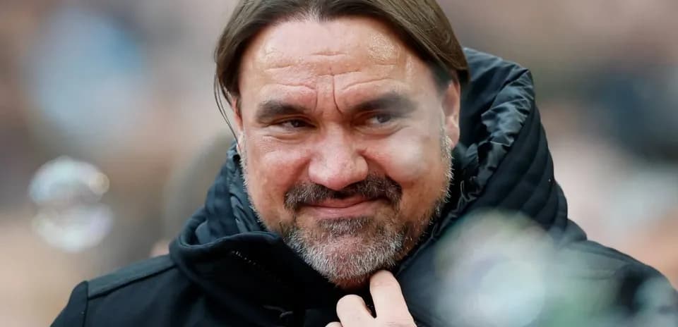 Entrenador con abrigo negro en el estadio