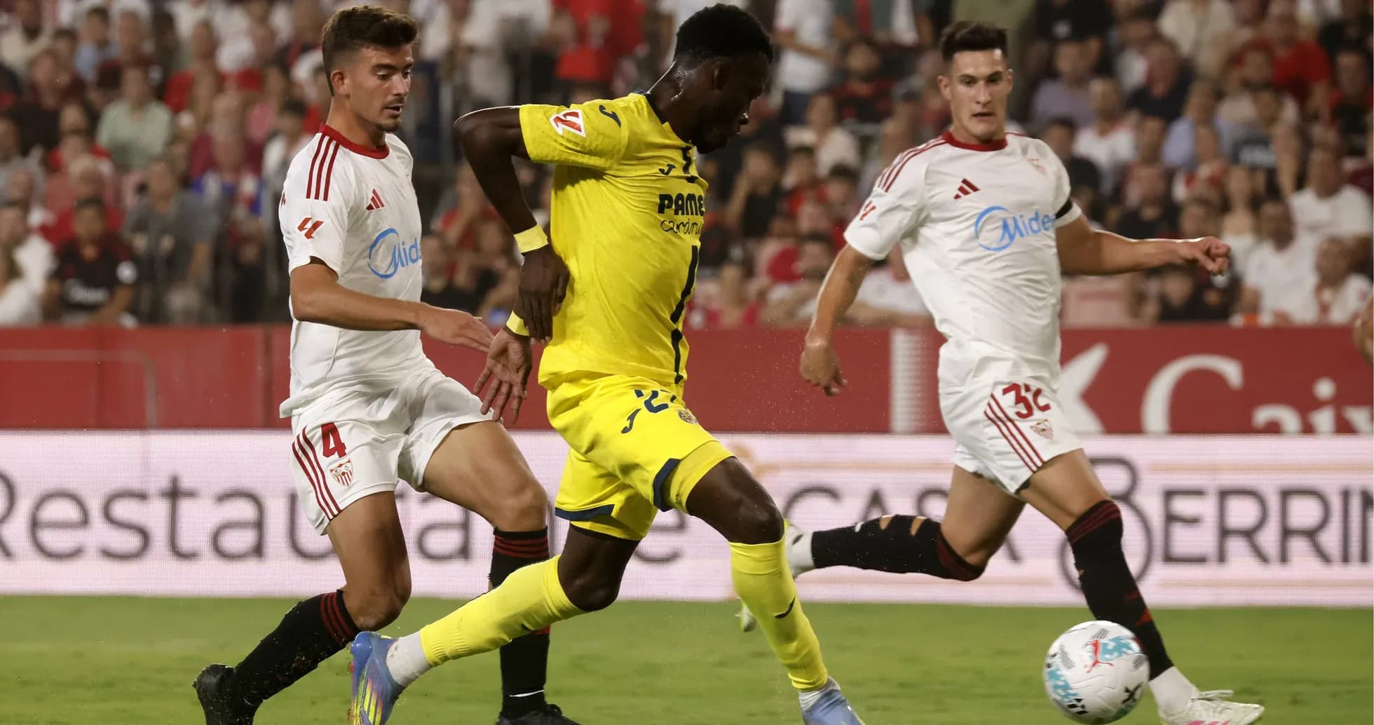 Jugador de Villarreal desafiando a dos de Sevilla