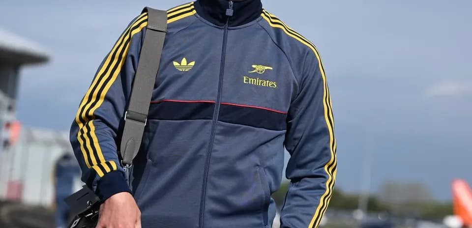 Jugador vestido con chándal caminando en aeropuerto