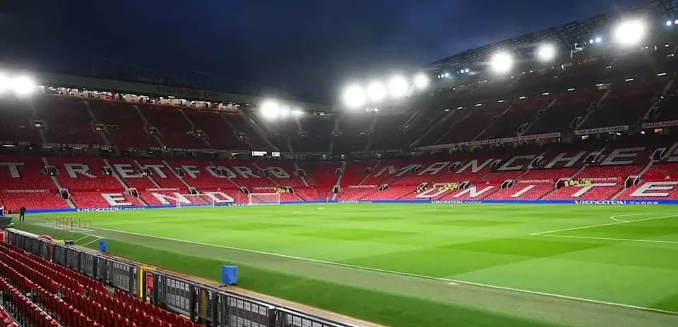 Estadio Old Trafford con gradas vacías y césped