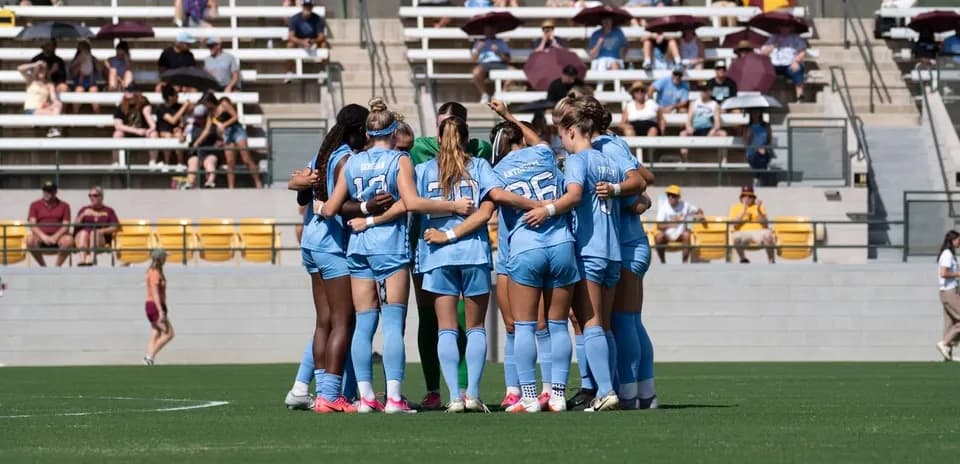 Equipo femenino de fútbol en círculo antes del partido