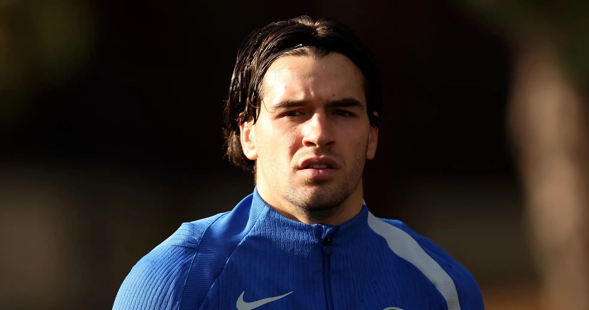 Jugador en traje de entrenamiento azul en campo