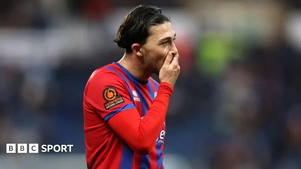 Jugador en camiseta roja con gesto pensativo durante el partido