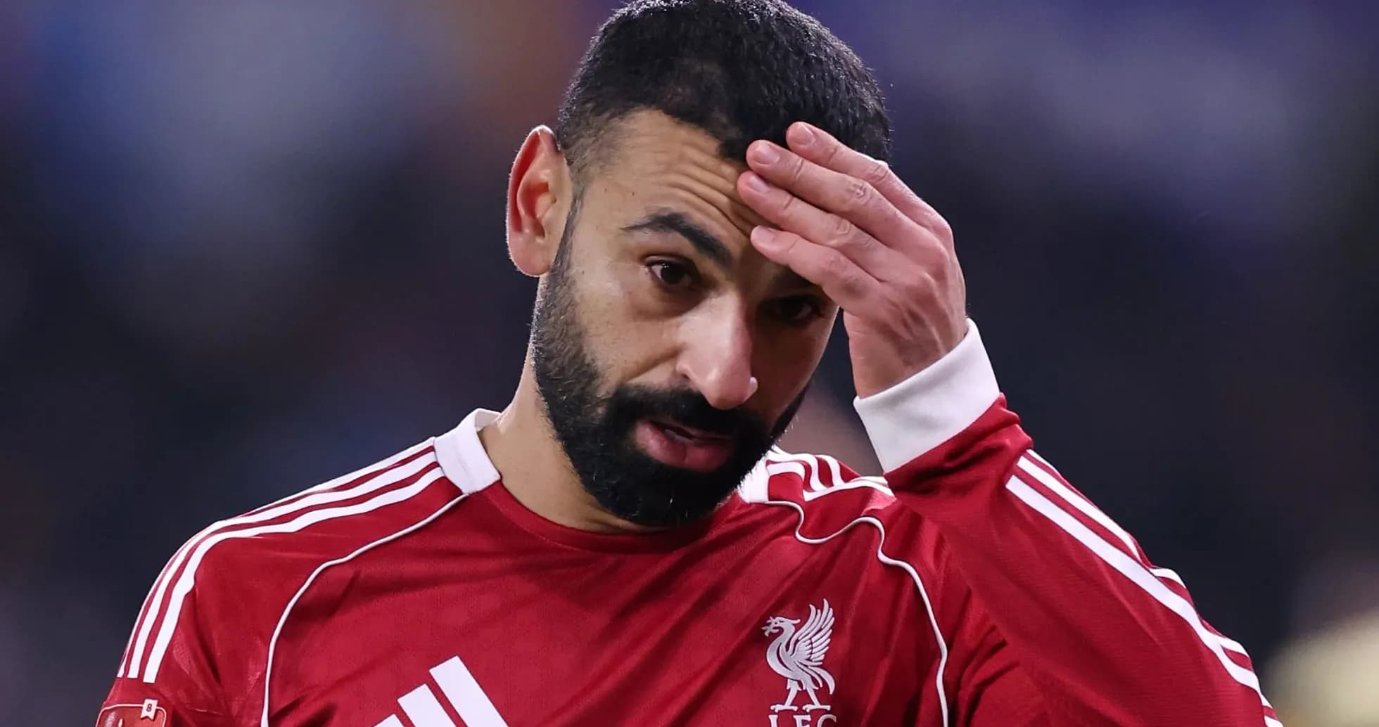 Jugador de Liverpool con camiseta roja, preocupado
