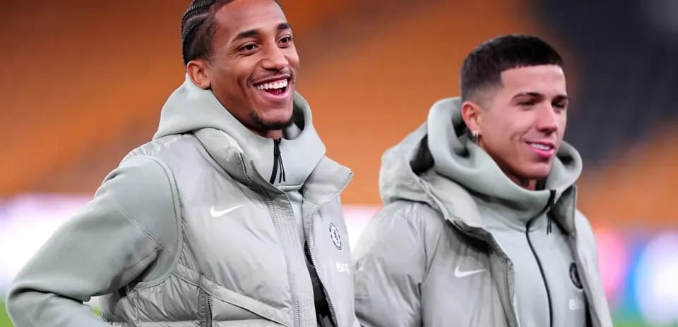 Dos jugadores sonrientes en el campo de entrenamiento