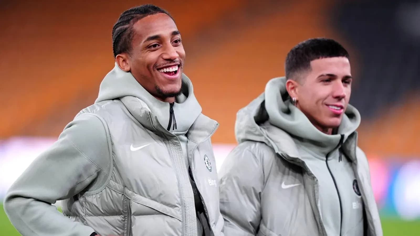 Dos jugadores sonrientes en el campo de entrenamiento