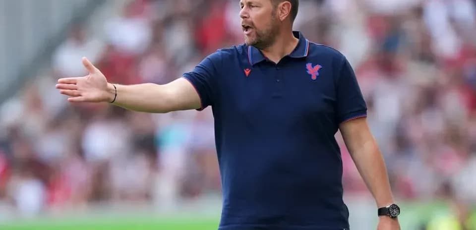 Entrenador dando instrucciones desde la banda del campo
