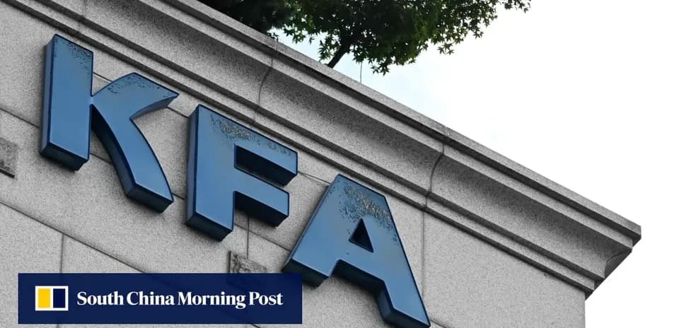 Letrero de KFA en edificio con árboles al fondo