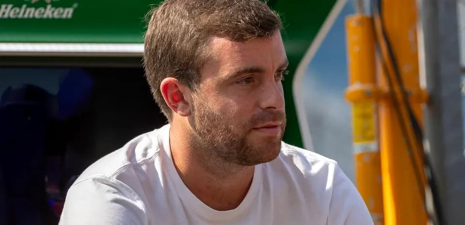 Hombre sentado con camiseta blanca, fondo verde