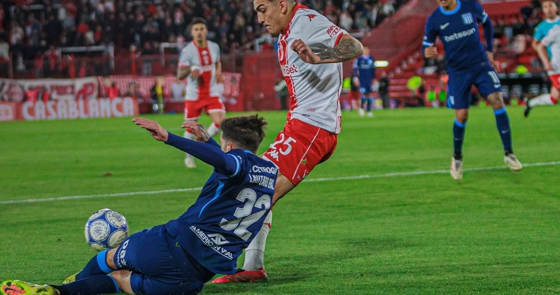 Jugador de Huracán esquivando una entrada de Racing