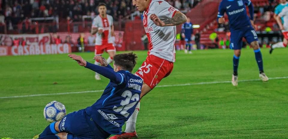 Jugador de Huracán esquivando una entrada de Racing