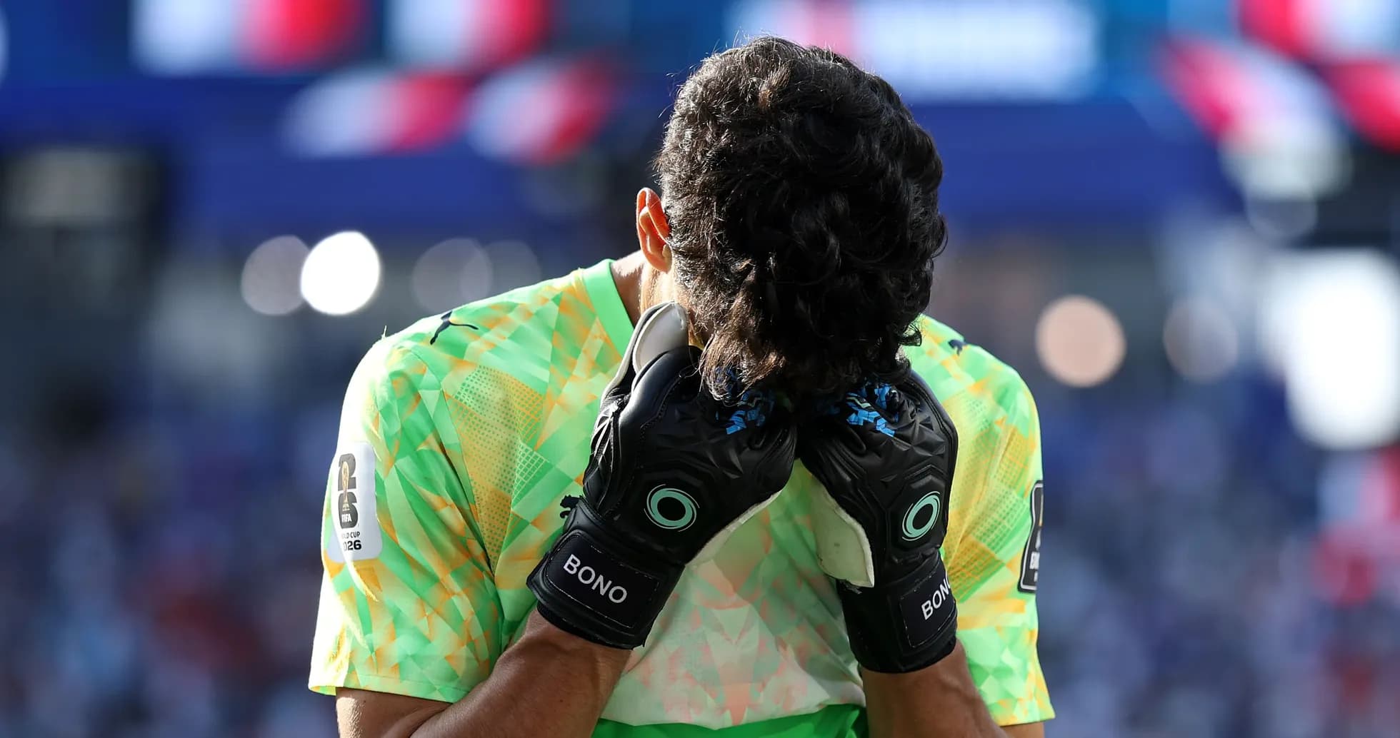 Portero con guantes cubriendo su rostro en el campo