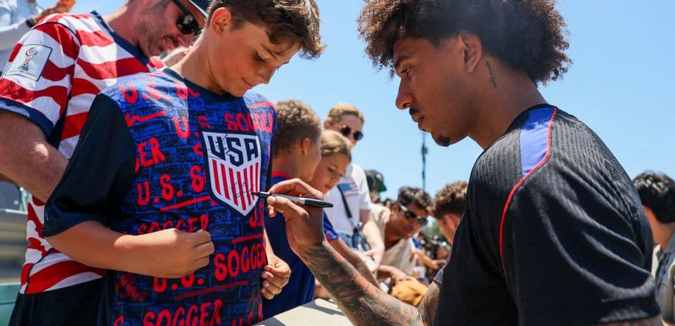 Jugador firmando autógrafo a un niño