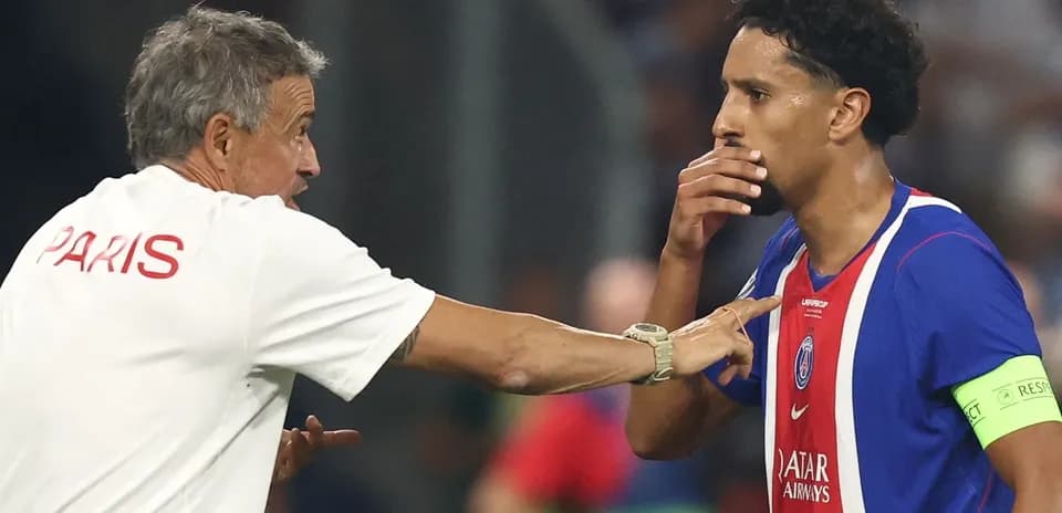 Entrenador hablando con jugador en el banquillo