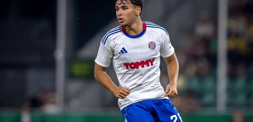 Jugador con camiseta blanca y pantalones azules en el campo