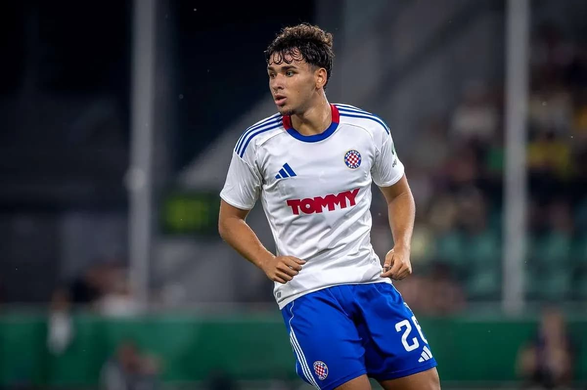Jugador con camiseta blanca y pantalones azules en el campo