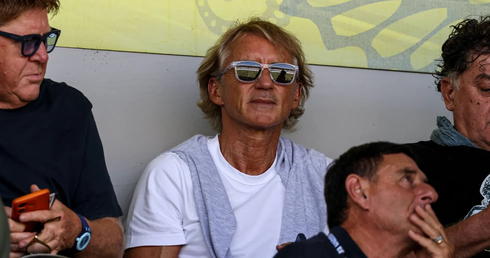 Hombres sentados en un palco viendo el partido