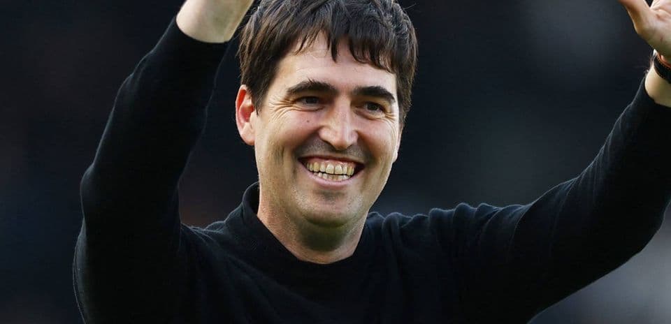 Entrenador saludando al público con una sonrisa
