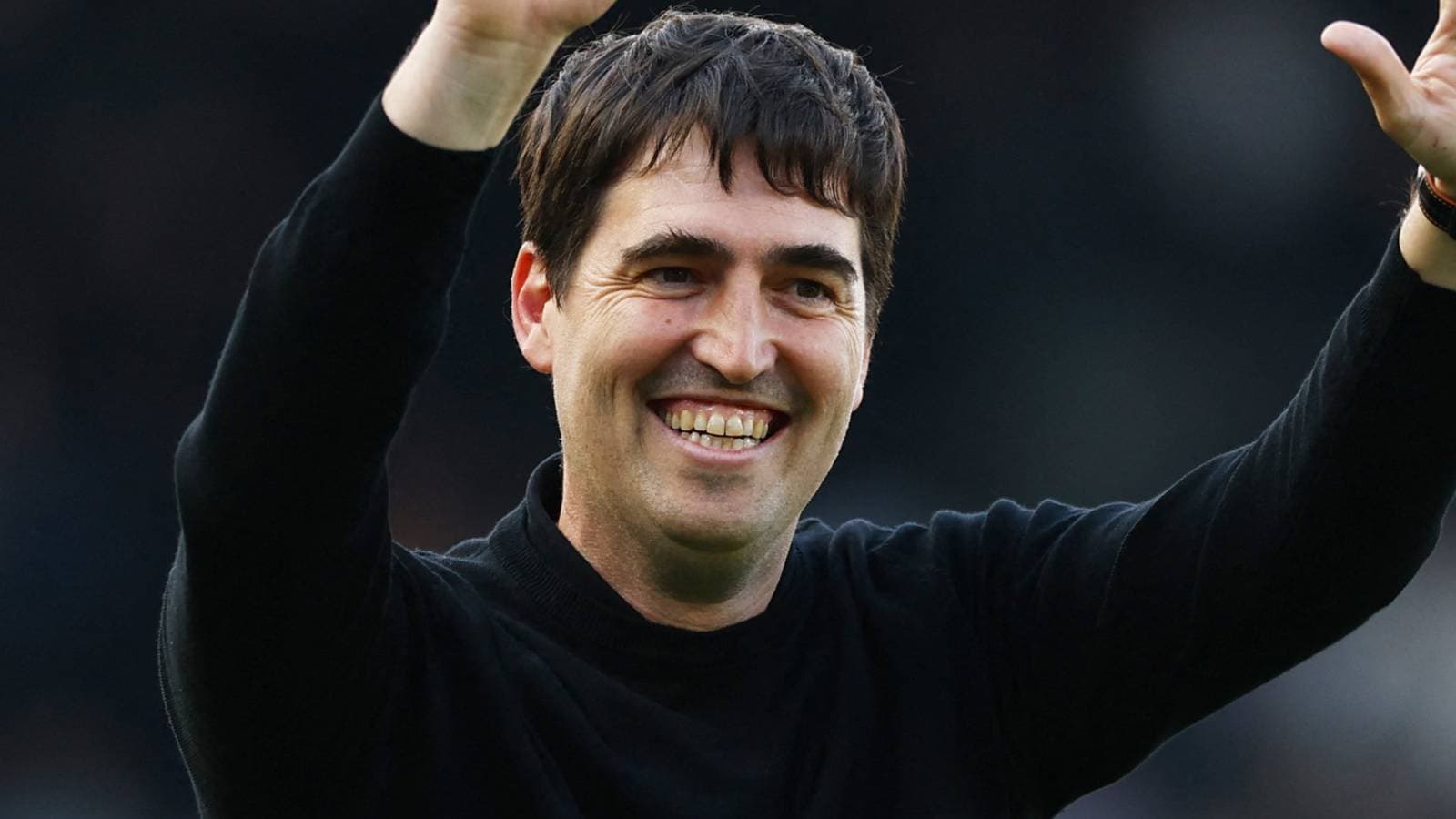 Entrenador saludando al público con una sonrisa