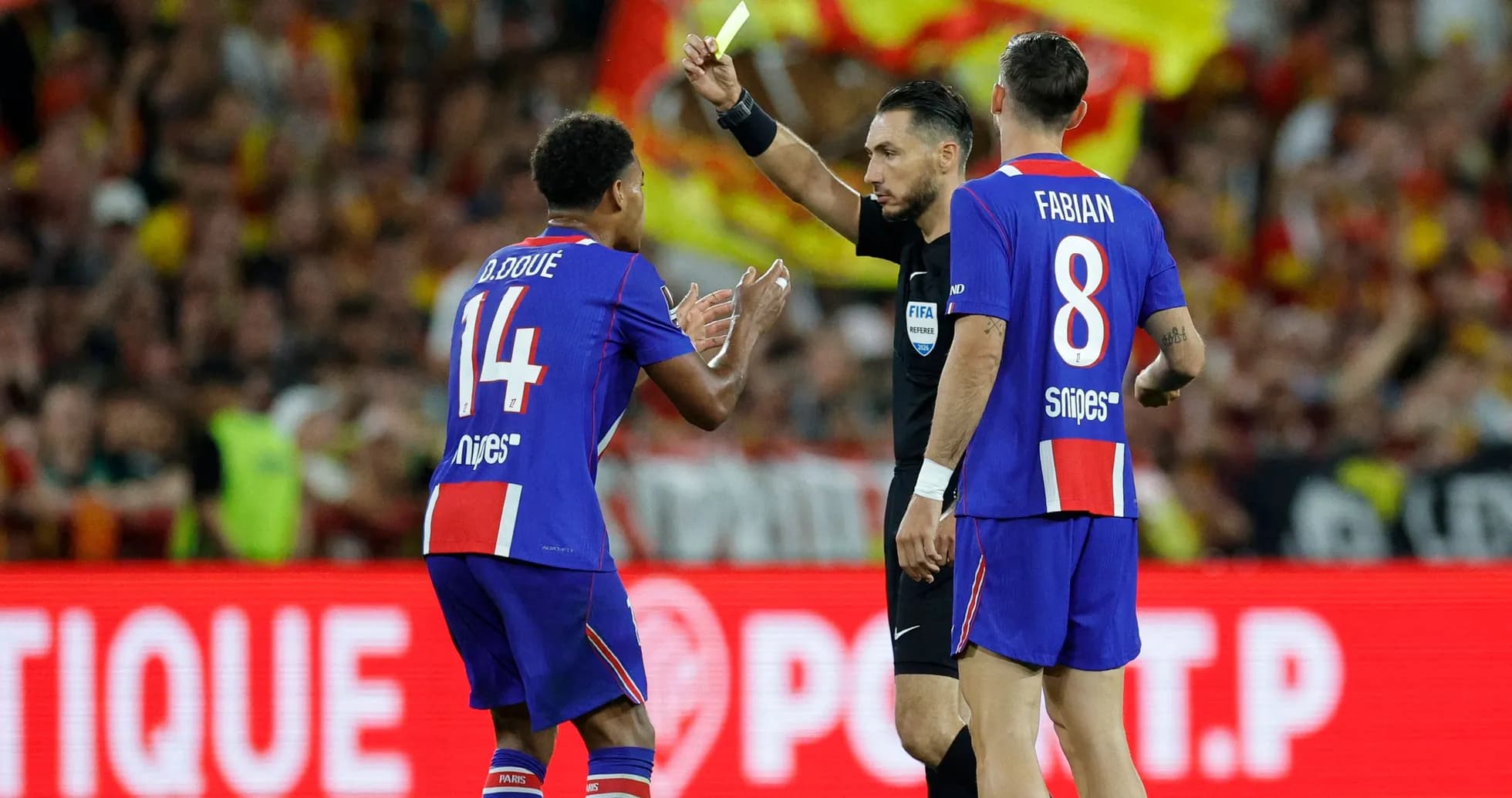 Árbitro mostrando tarjeta amarilla a jugador de fútbol