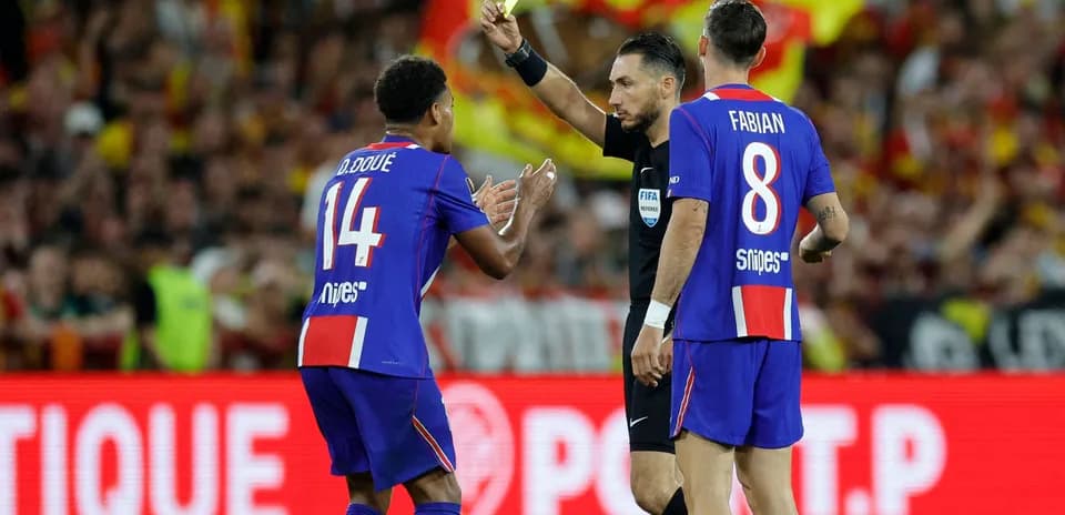 Árbitro mostrando tarjeta amarilla a jugador de fútbol