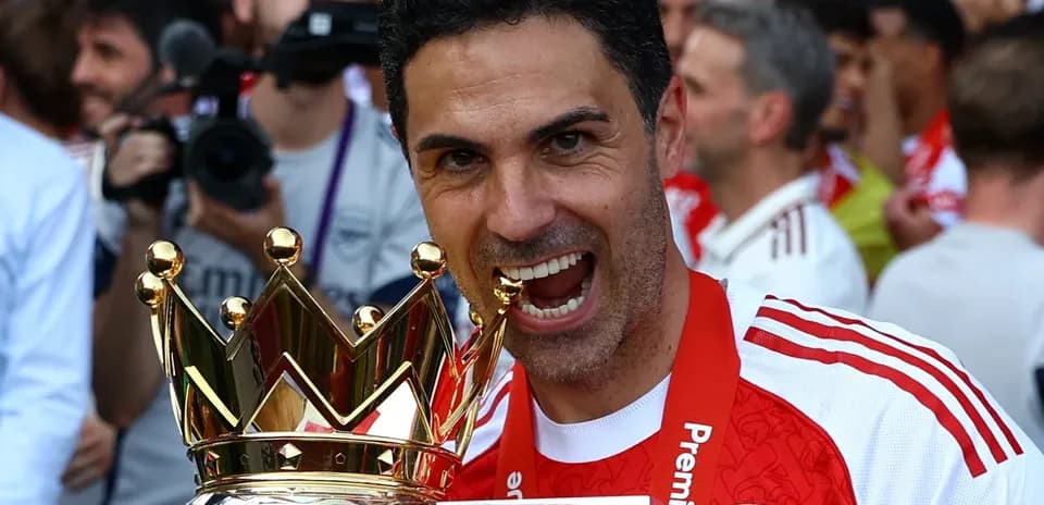Entrenador del Arsenal sosteniendo el trofeo de la Premier League