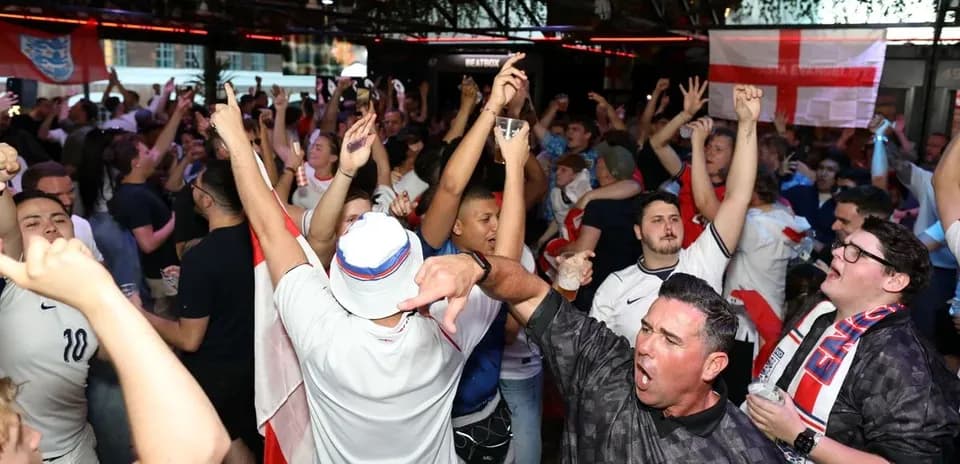 A crowd of fans celebrating in a bar