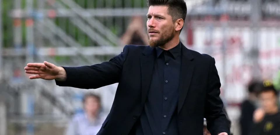 Entrenador dirigiendo desde la línea de banda