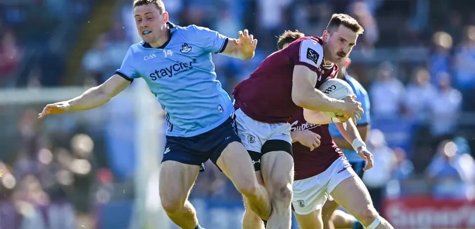Jugador de Galway avanzando mientras es marcado por Dublín