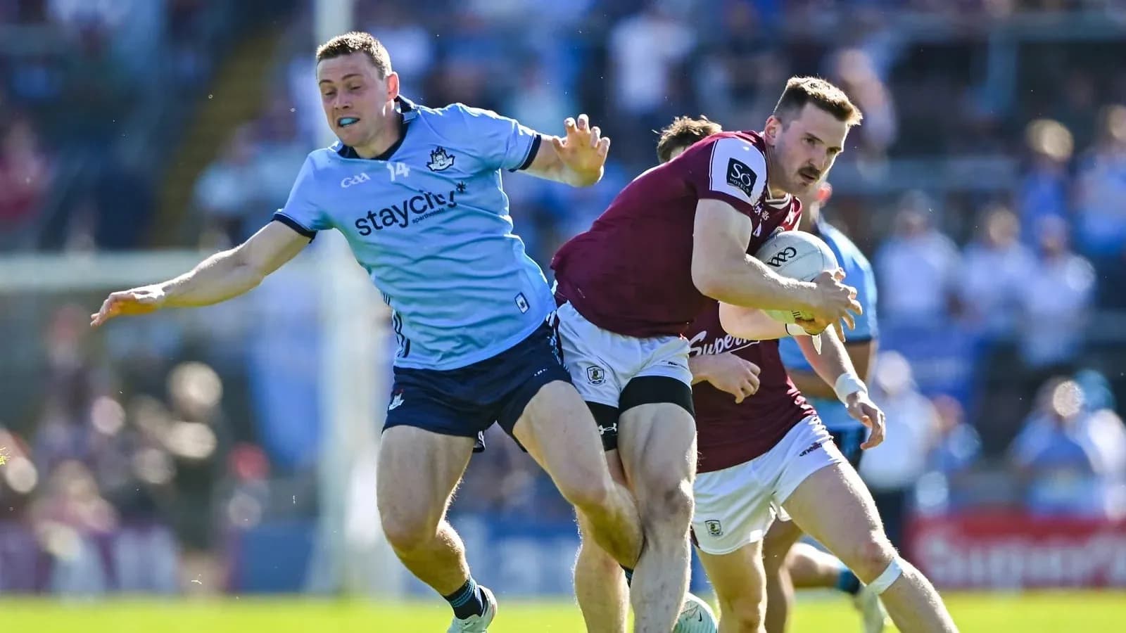 Jugador de Galway avanzando mientras es marcado por Dublín