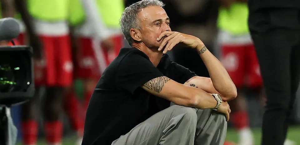 Entrenador sentado pensativo durante el partido