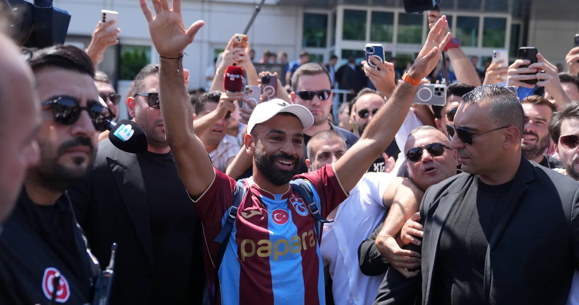 Jugador saludando a los aficionados rodeado de seguridad
