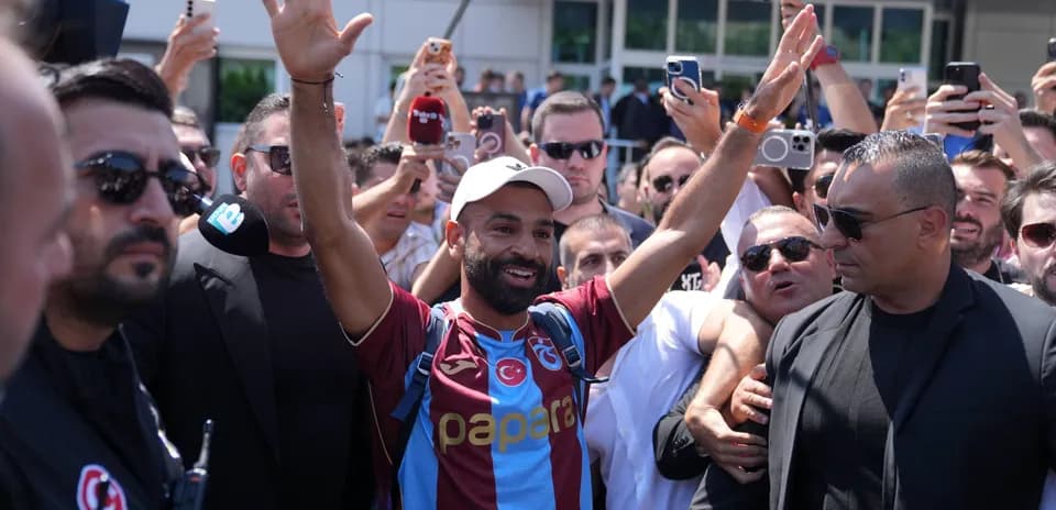 Jugador saludando a los aficionados rodeado de seguridad
