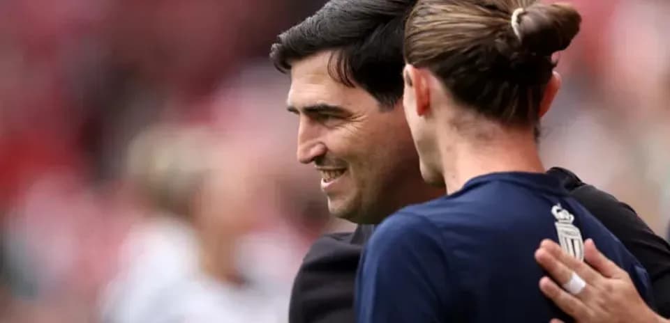 Entrenador y jugador se saludan antes del partido
