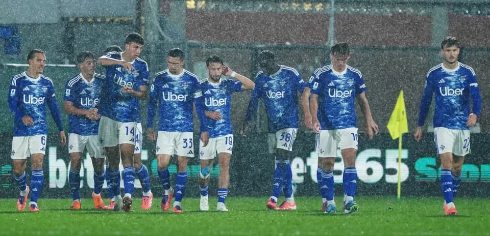 Equipo de Como en partido de fútbol bajo la lluvia