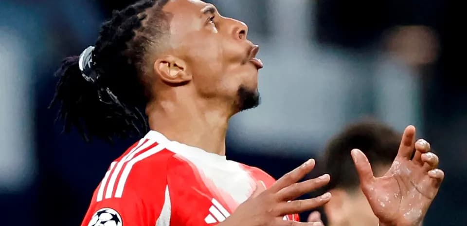 Jugador de fútbol con camiseta roja mirando al cielo