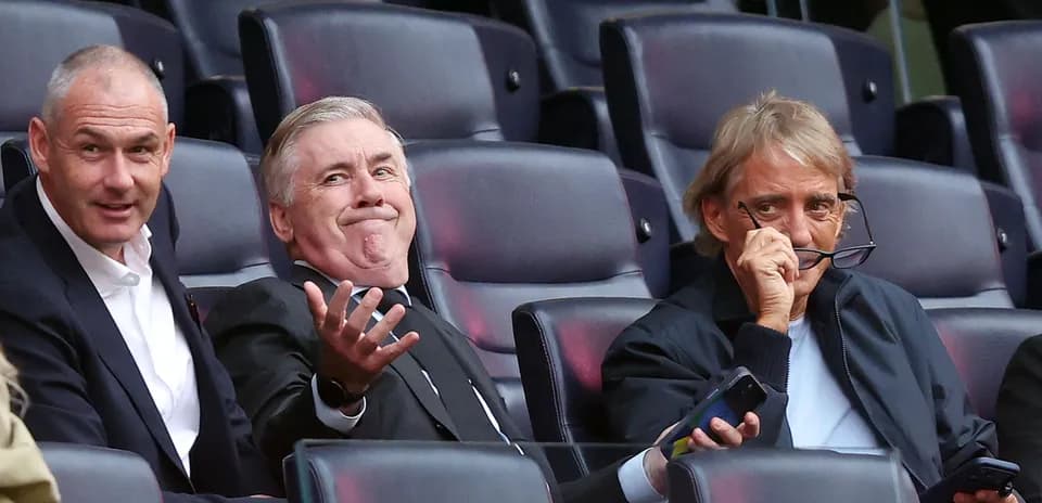 Tres hombres sentados en un estadio durante un evento