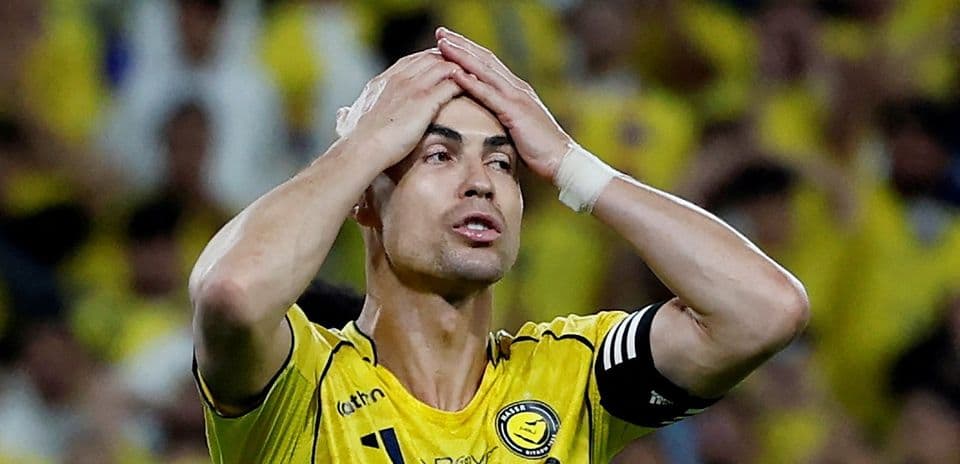 Jugador con camiseta amarilla con las manos en la cabeza
