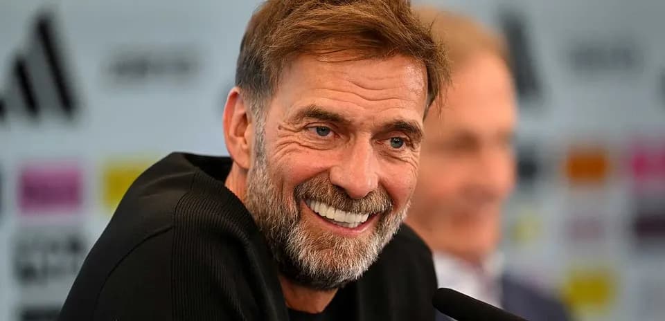 Entrenador sonriendo durante la rueda de prensa