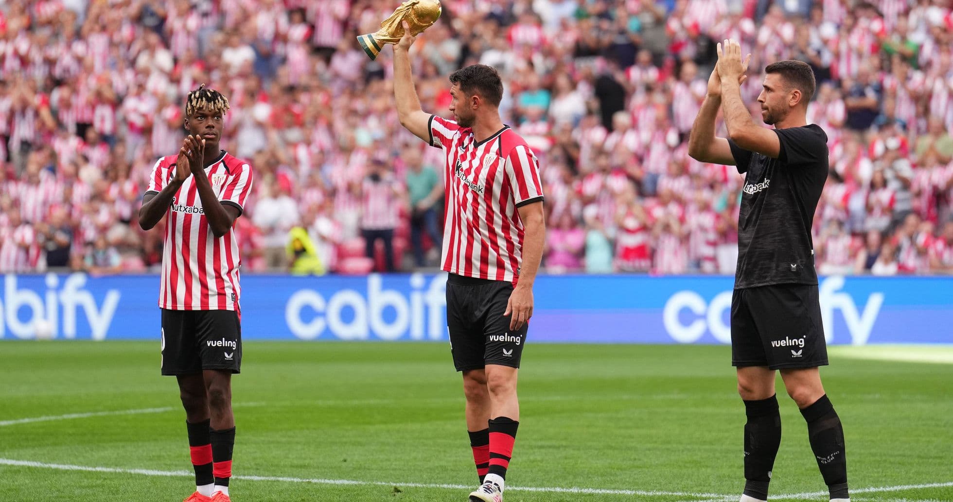 Jugadores de Athletic Club celebrando con trofeo en estadio