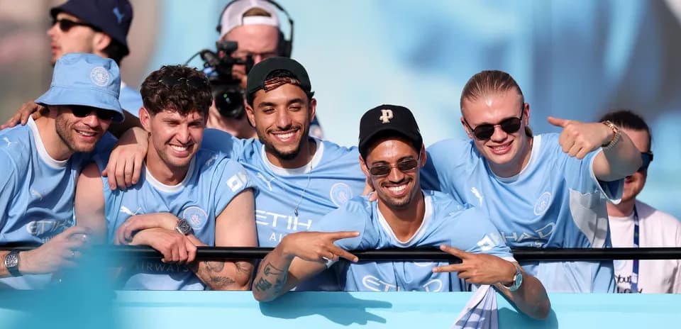 Cinco aficionados de Manchester City en la grada