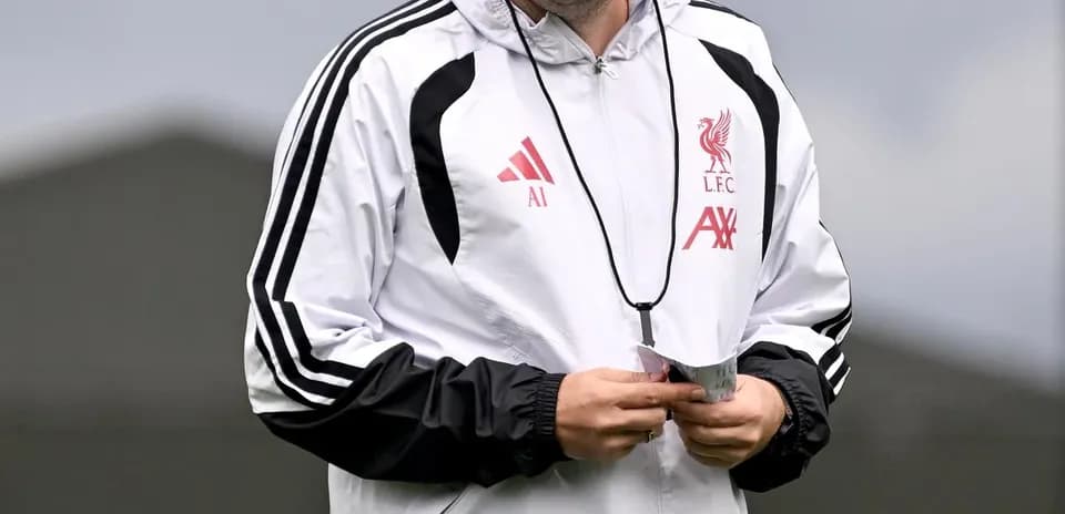 Entrenador de Liverpool caminando durante sesión de entrenamiento