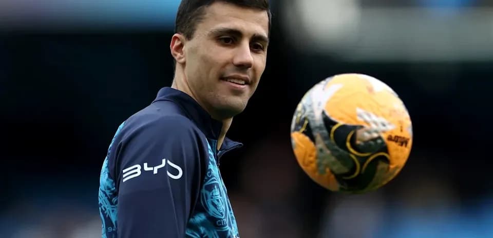 Jugador sosteniendo un balón de fútbol durante calentamiento